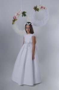 Vestido de primera comunión en gasa blanca Evelyn con fajín en gasa gris perla y falda de tablas